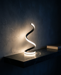 Helix Lamp lit warm on a dark stone shelf