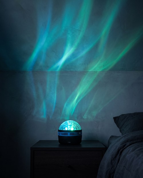 Aurora Projector casting green and cyan light across a bedroom wall