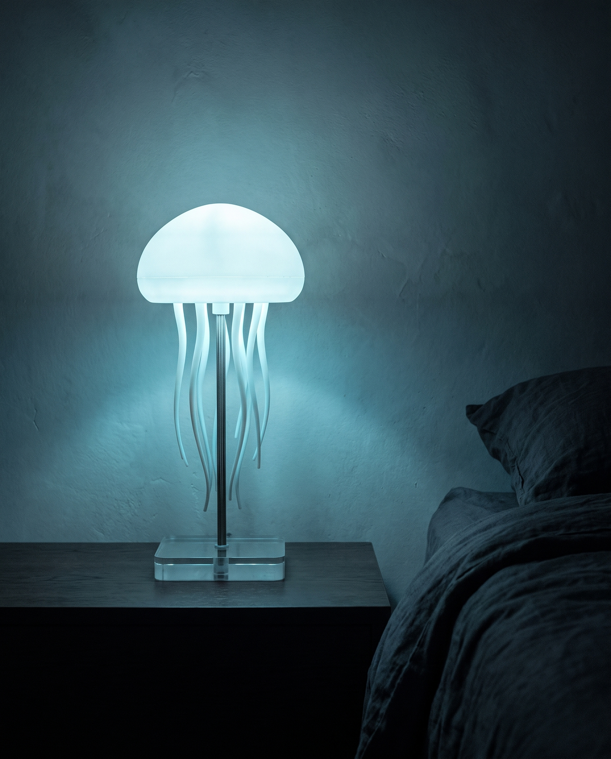 Jellyfish Lamp glowing cyan on a bedside table