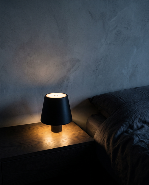 Cordless Table Lamp in black, lit on a bedside table