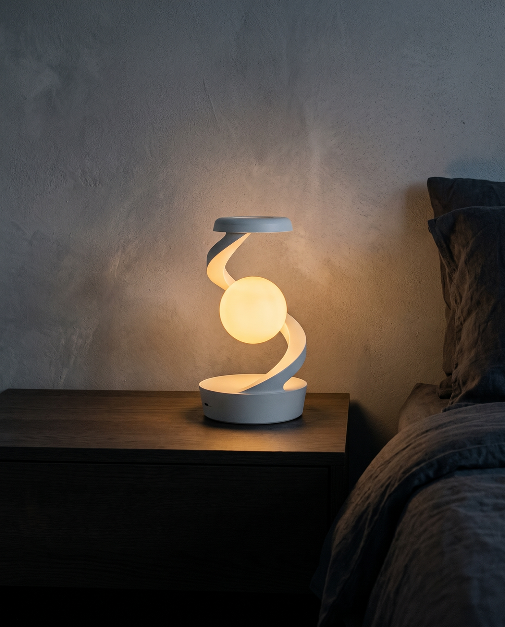 Orbit Lamp glowing warm white on a bedside table at night