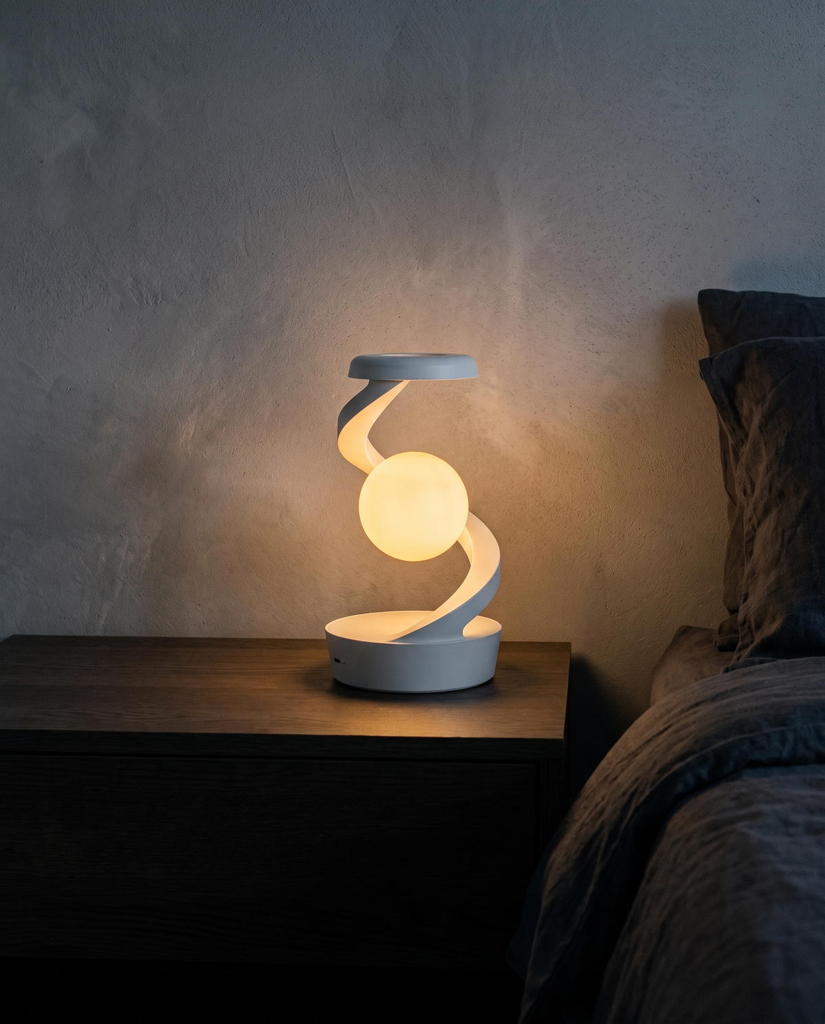 Orbit Lamp glowing warm white on a bedside table at night
