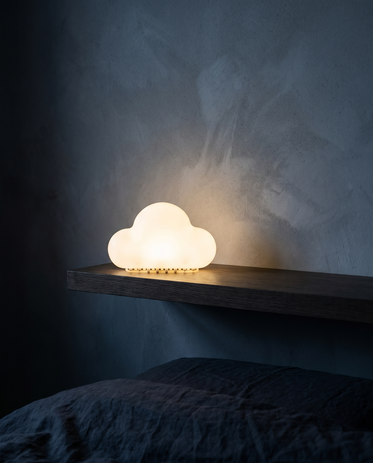 Cloud Light glowing on a floating shelf above a bed