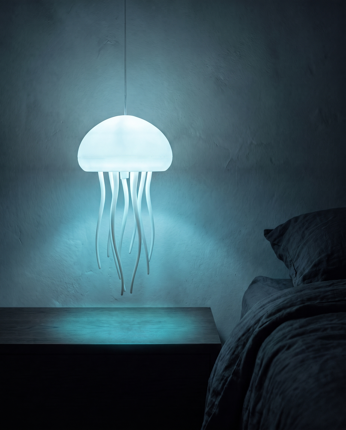 Jellyfish Lamp hanging from a cord, glowing cyan above a bedside table