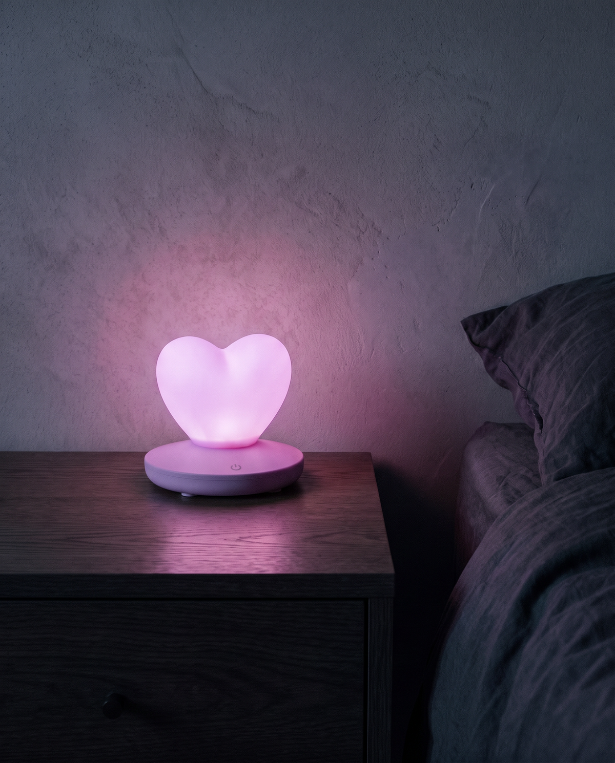 Heart Lamp in purple, glowing on a bedside table